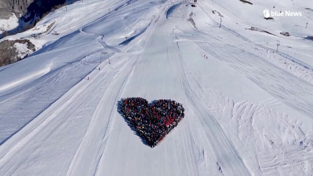 Des skieurs forment un cœur en soutien aux victimes de Crans-Montana.
