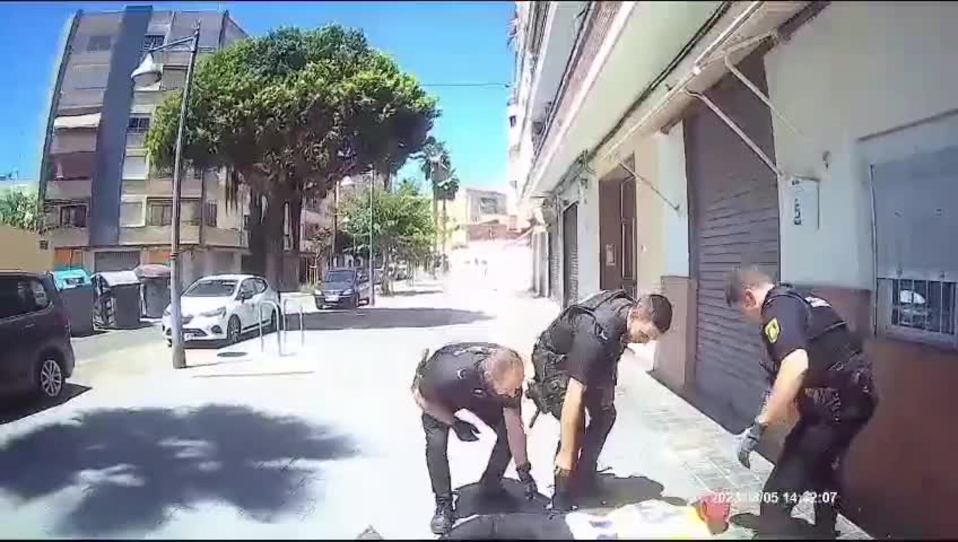 Tres agentes de la Policía Nacional junto al hombre que llevaba un cuchillo y un gran palo por la calle, tras ser reducido.