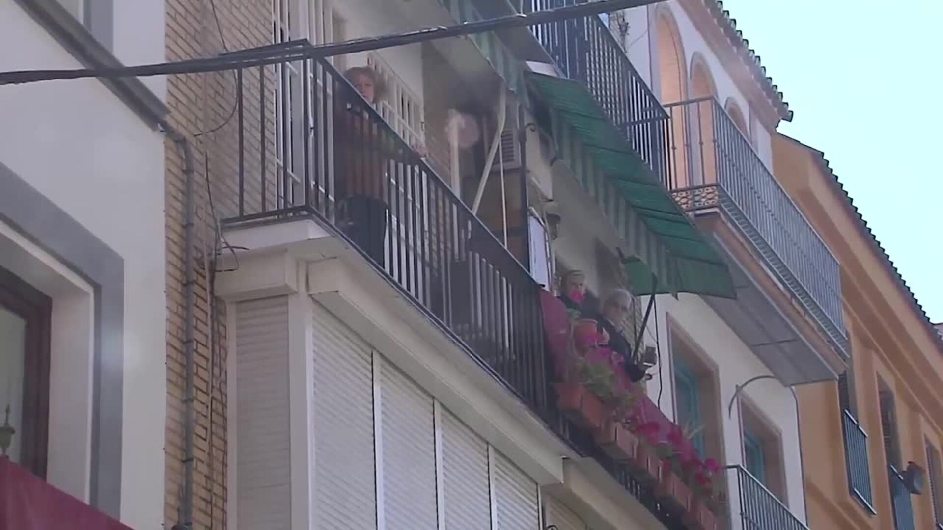 Vecinos de la trianera calle de Pureza (Sevilla) rezan el Ángelus a las puertas de la Semana Santa