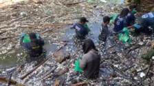 Un grupo de activistas limpian un río en Indonesia durante el Día del Agua