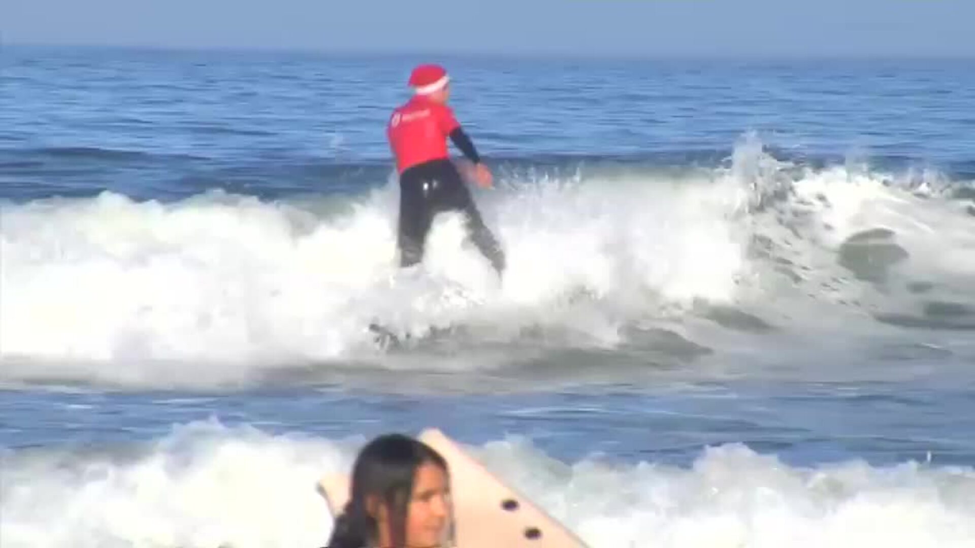 Cientos de Papás Noel surfean en la playa pontevedresa de Nigrán