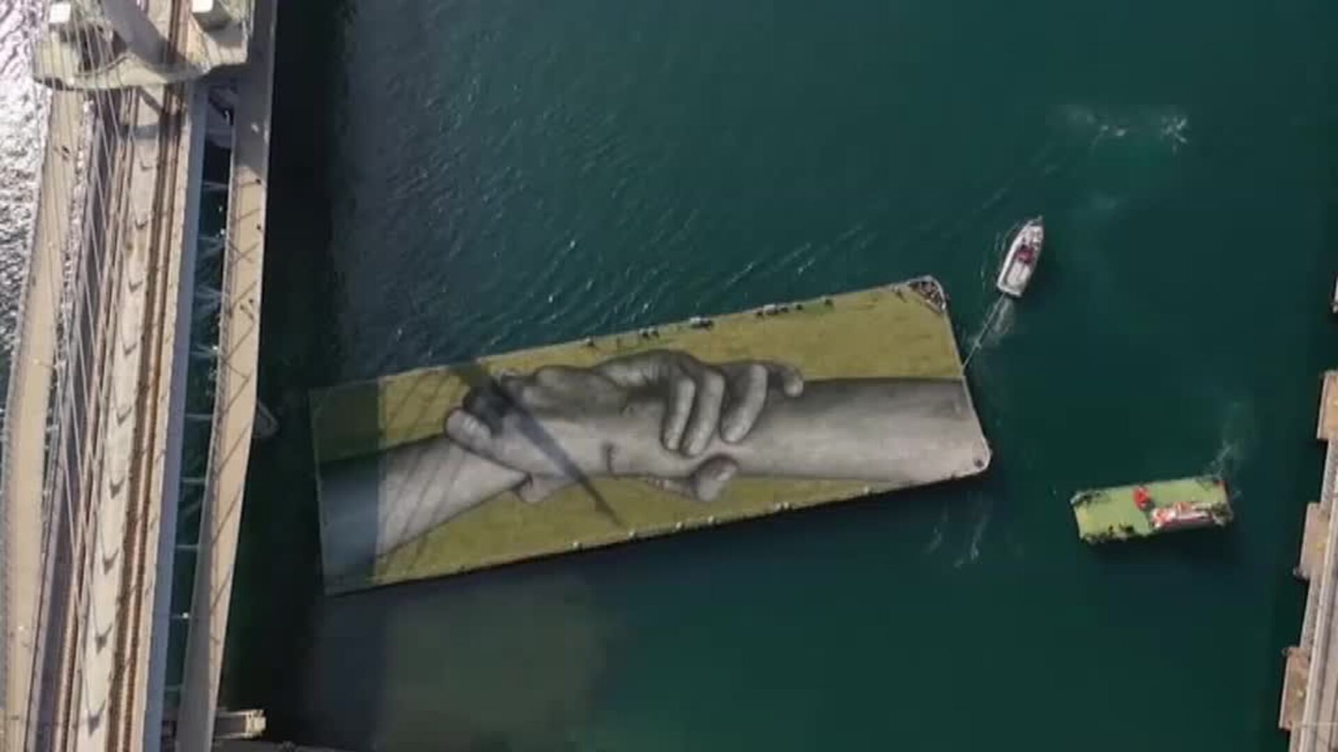 El artista francés Saype pinta con spray dos manos gigantes en el Cuerno de Oro de Estambul