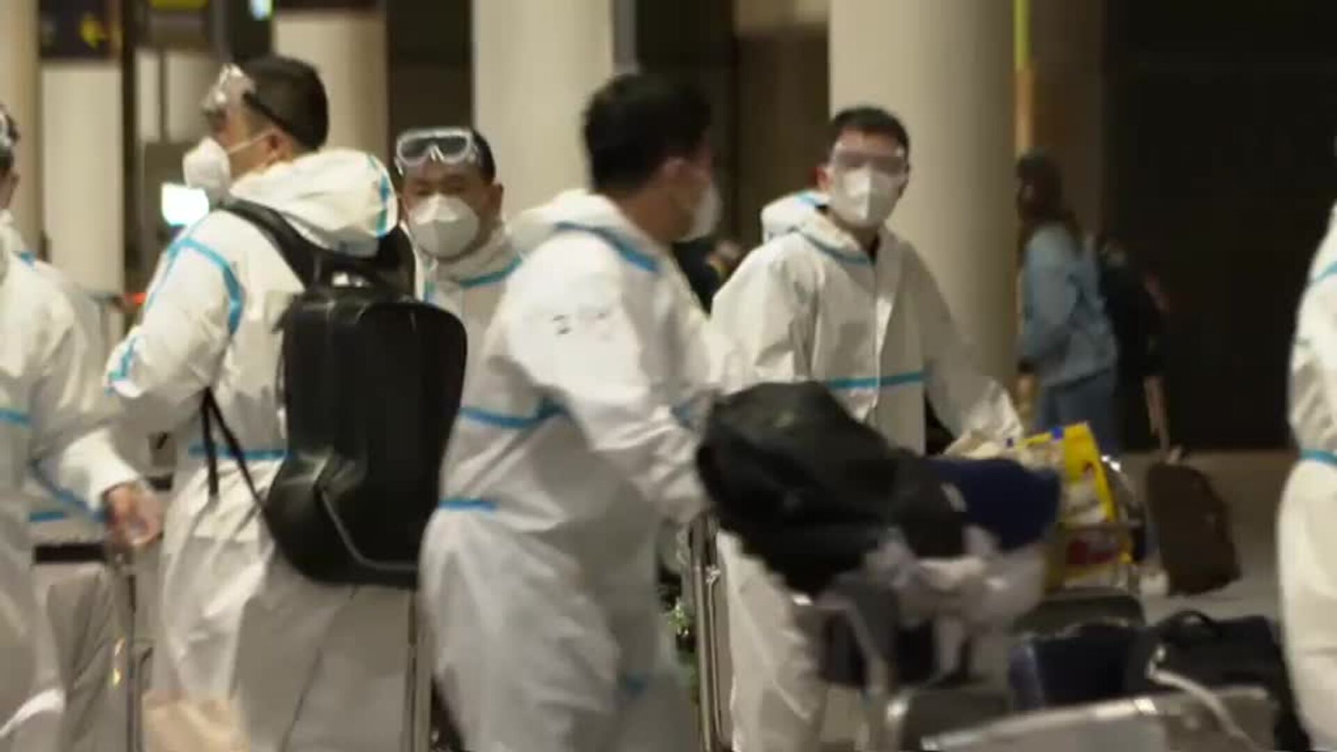 Marinos chinos aterrizan en Barcelona con trajes EPI completos, mascarillas y gafas