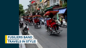 Army band plays song... on rickshaws through busy Hanoi