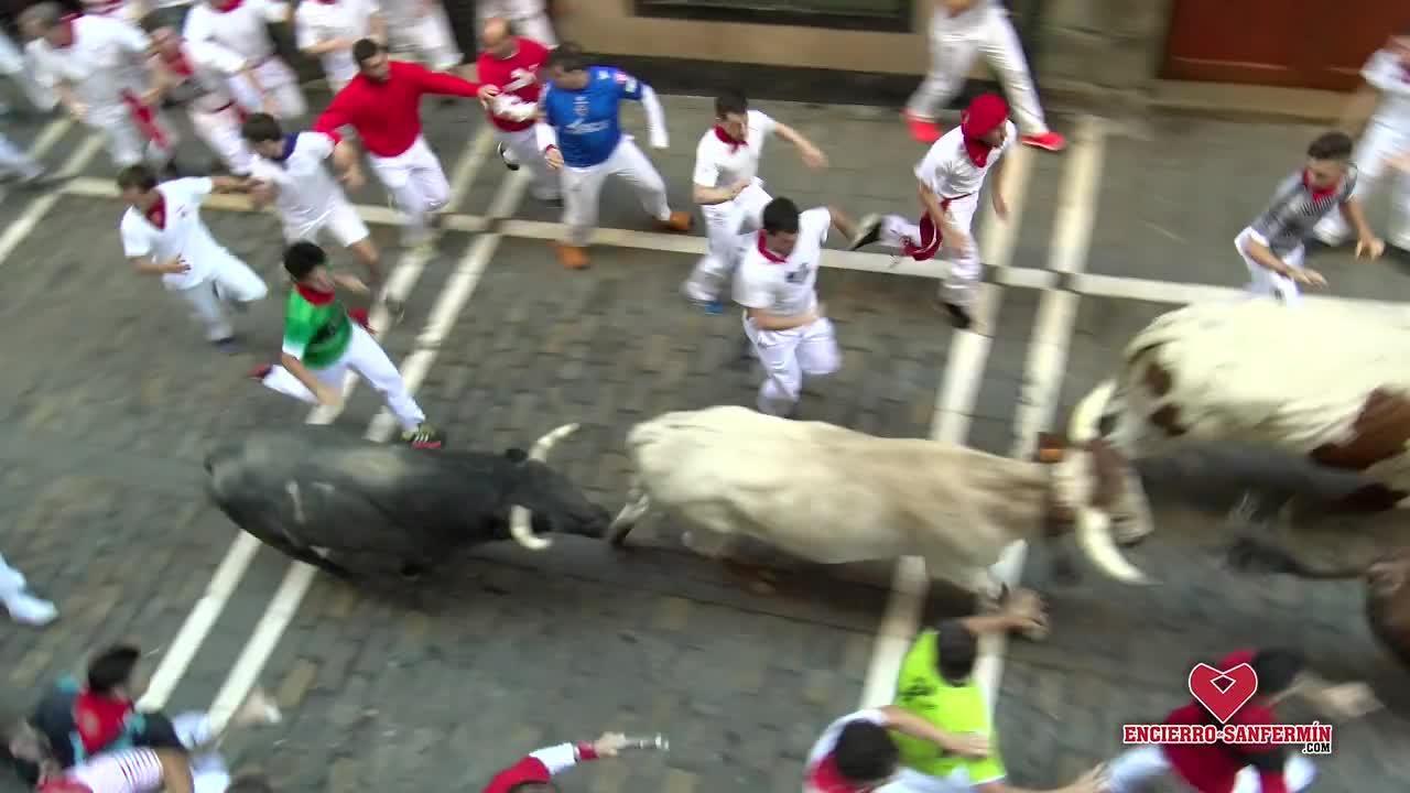 En el tercer encierro de San Fermín 2018, varios mozos corren ante dos toros de la ganadería gaditana de Cebada Gago