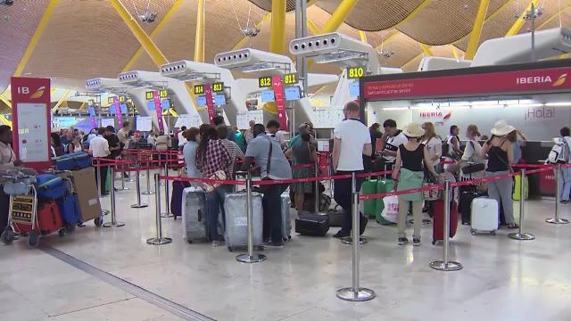 Un viajero fotografía el panel de salidas en el aeropuerto de El Prat (Barcelona)