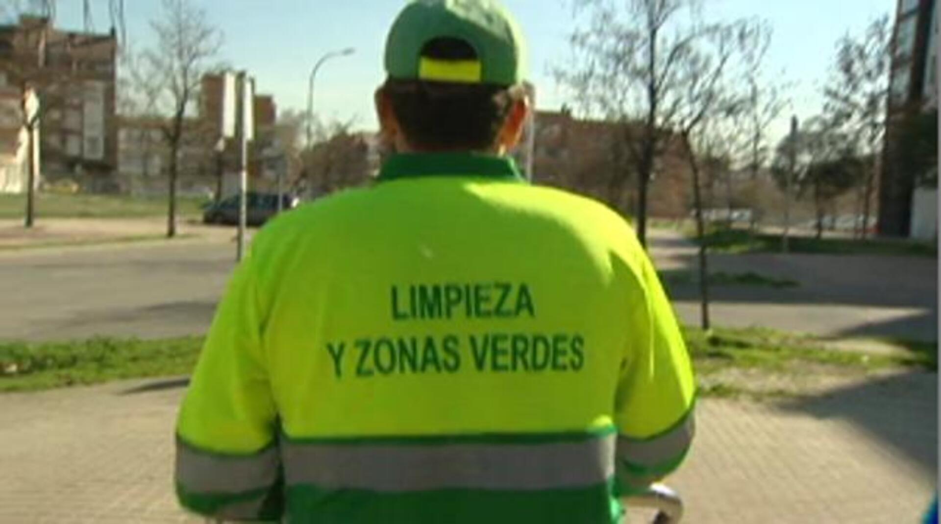 Un barrendero del servicio municipal de limpieza recoge hojas secas en la zona norte de la capital
