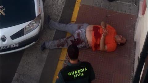 Un operario limpia los restos de sangre en la calle de Olivares donde sucedió el crimen