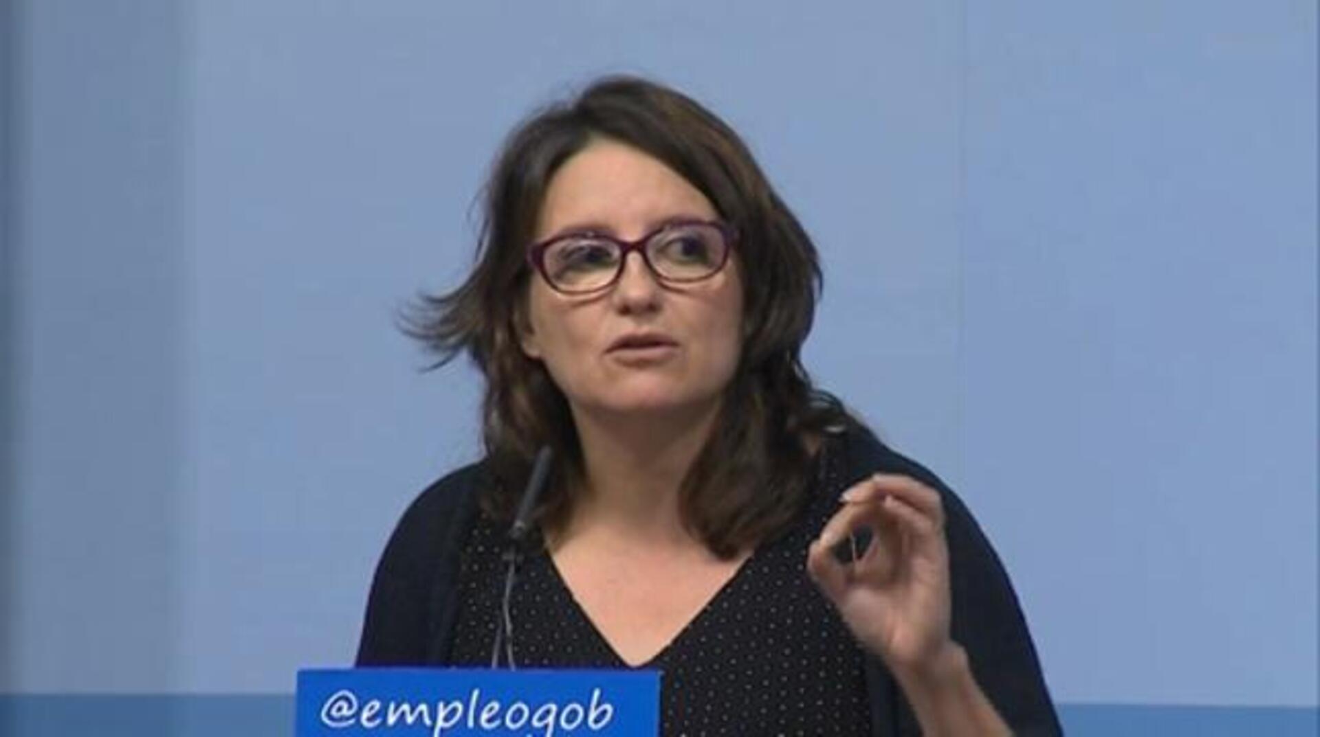 Mónica Oltra baja la escaleras del hemiciclo en presencia de Puig