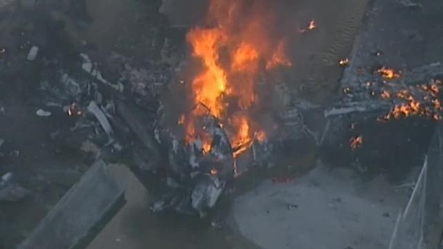 Empleados del centro comercial DFO se consuelan tras estrellarse una avioneta en el edificio cerca del aeropuerto australiano en Melbourne