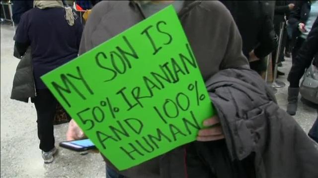 En el aeropuerto de Los Ángeles, Teija, de 7 años, espera a su padre, que ha sido retenido en Irán. Sostiene un cartel en el que se puede leer: «Quiero abrazar a mi padre»