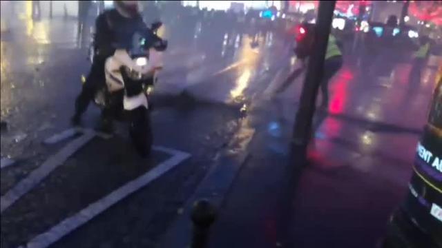 Un policía apunta con su arma a la multitud que les asa nueva protesta de los &#039;chalecos amarillos&#039;