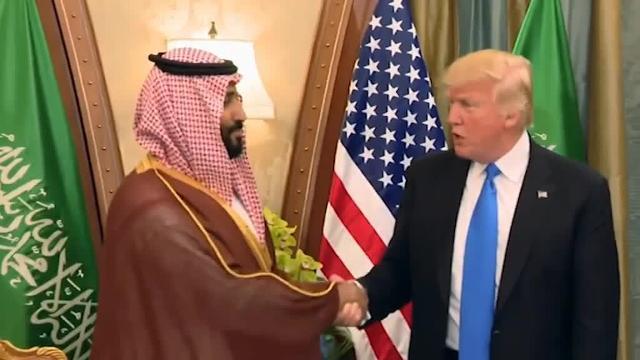 Dos mujeres fotografían un cartel sobre la visita de Trump en el centro de Jerusalén