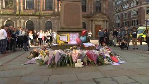 Homenaje a las víctimas del último atentado con flores, junto a un cartel contra Daesh, cerca del mercado de Borough, este domingo en Londres