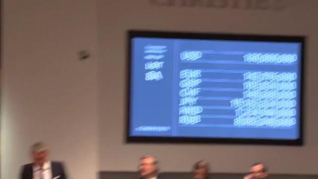 Dos miembros de seguridad, junto a «Salvator Mundi», de Leonardo da Vinci, en la sala Christie's de Nueva York