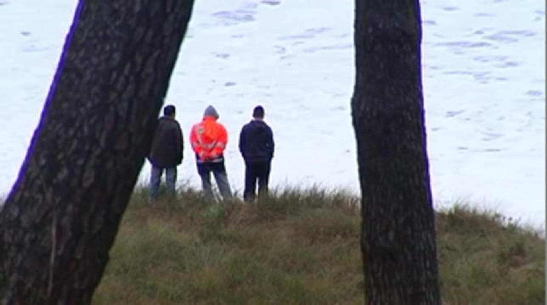 Varias personas contemplan las olas esta tarde en la entrada del puerto de Tapia de Casariego, en el occidente de Asturias