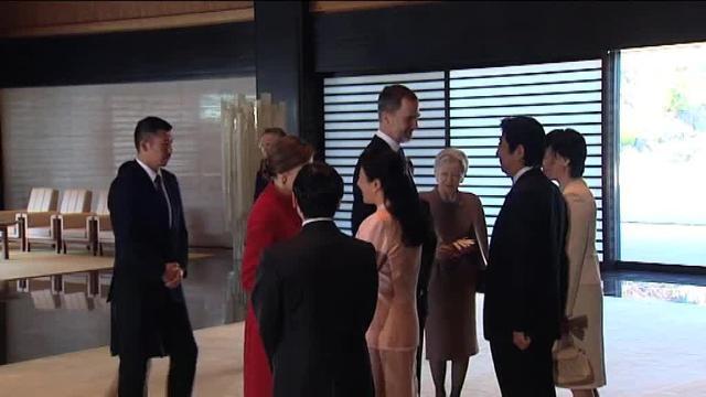 Don Felipe (c) y Doña Letizia (i) saludan al robot Asimo en Japón