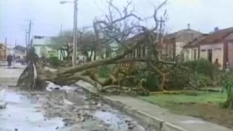 Personas intentan cruzar un río debido al derrumbe del único puente que conecta con el sur del país, tras el paso del huracán Matthew