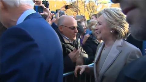 Hillary Clinton saluda a sus seguidores, acompañada por su marido Bill, al ir a votar en la jornada electoral en Estados Unidos