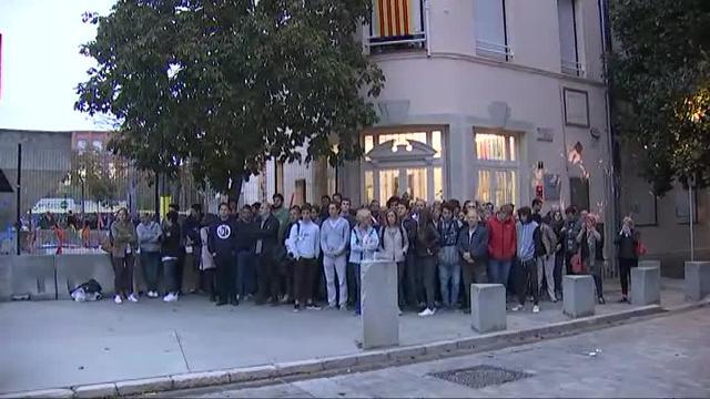 Agentes antidisturbios de la Policía Nacional y de los Mossos d' Esquadra discuten frente a un instituto