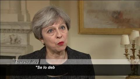 Theresa May, primera ministra de Reino Unido, charla con oficiales de la Policía junto a la torre Grenfell